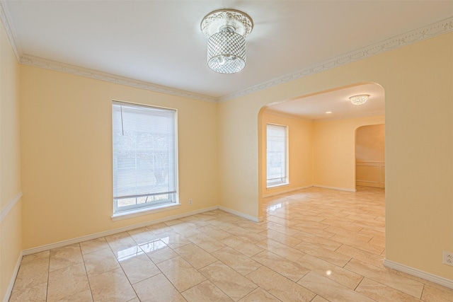 spare room with an inviting chandelier, baseboards, arched walkways, and ornamental molding