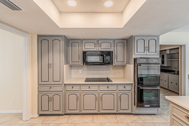 kitchen with black appliances, light countertops, gray cabinets, and visible vents