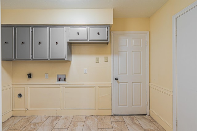 clothes washing area featuring hookup for a washing machine, a decorative wall, hookup for an electric dryer, cabinet space, and mail area