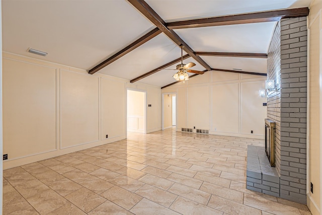 unfurnished living room with a brick fireplace, visible vents, a decorative wall, and ceiling fan