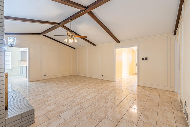 unfurnished living room with lofted ceiling with beams, a decorative wall, and a ceiling fan