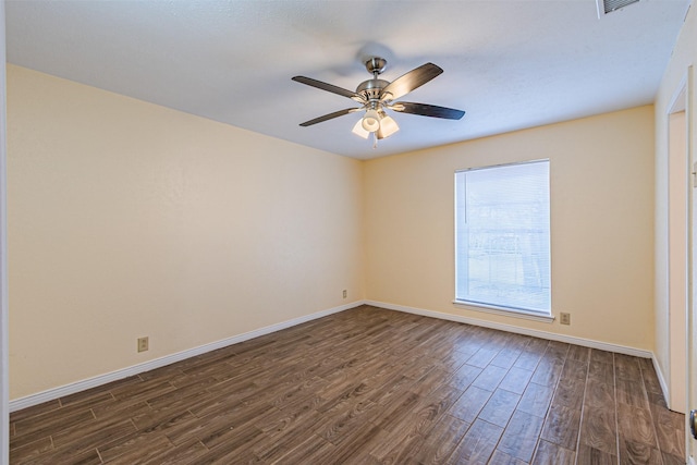 unfurnished room featuring a ceiling fan, baseboards, and dark wood-type flooring