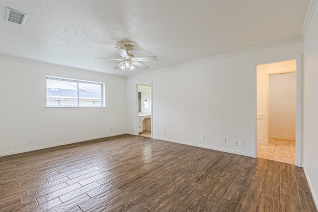 unfurnished room with crown molding, dark wood finished floors, visible vents, and a ceiling fan