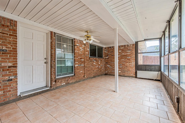 unfurnished sunroom with a ceiling fan