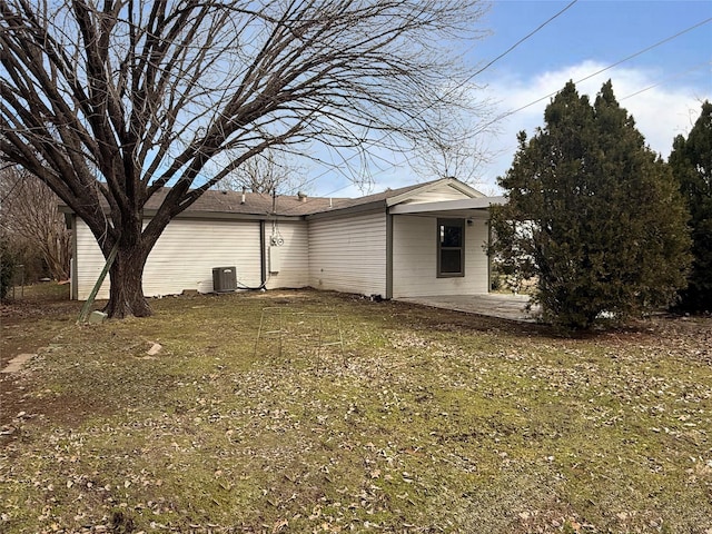 back of house featuring central AC, a patio, and a lawn