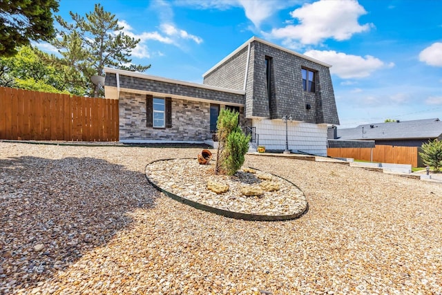 view of front of property with a shingled roof and fence