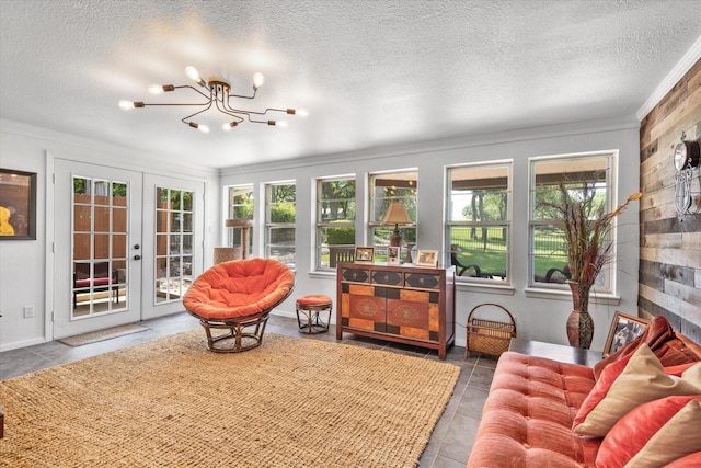 sunroom featuring a chandelier, french doors, and a healthy amount of sunlight