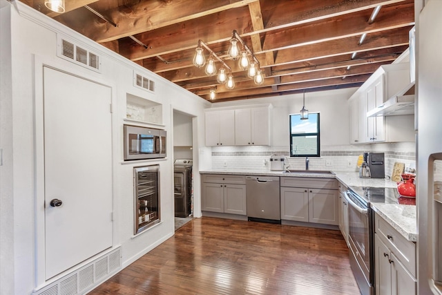 kitchen featuring visible vents, stainless steel appliances, a sink, and decorative light fixtures