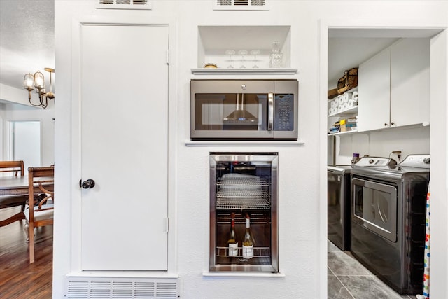 interior space with visible vents, beverage cooler, cabinet space, and washer and clothes dryer