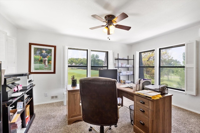 home office with baseboards, a ceiling fan, visible vents, and light colored carpet