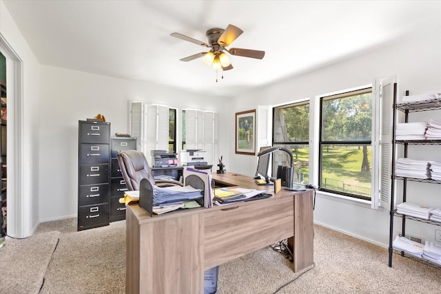 office area featuring baseboards, a ceiling fan, and light colored carpet