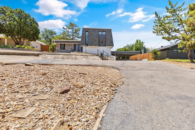 view of front of house with stone siding and fence