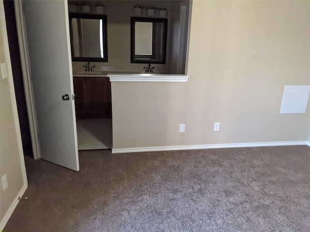 unfurnished bedroom featuring dark colored carpet and baseboards