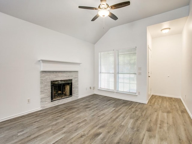 unfurnished living room with baseboards, a ceiling fan, lofted ceiling, light wood-style floors, and a fireplace