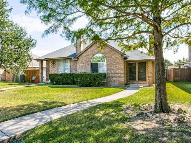 single story home with brick siding, a chimney, a front yard, and fence