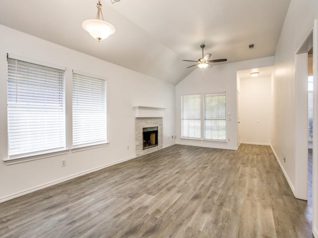 unfurnished living room featuring a fireplace, light wood-style flooring, vaulted ceiling, ceiling fan, and baseboards