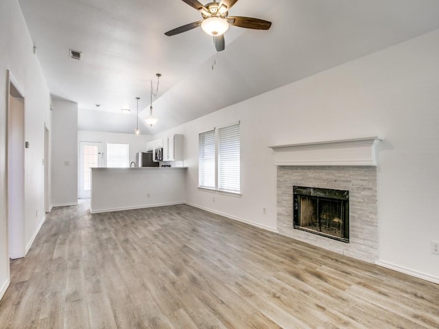 unfurnished living room with vaulted ceiling, light wood-style flooring, plenty of natural light, and visible vents