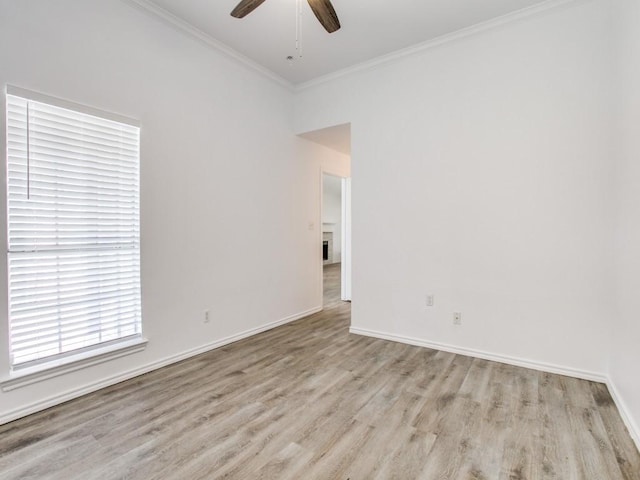 empty room with light wood-style floors, ceiling fan, baseboards, and crown molding