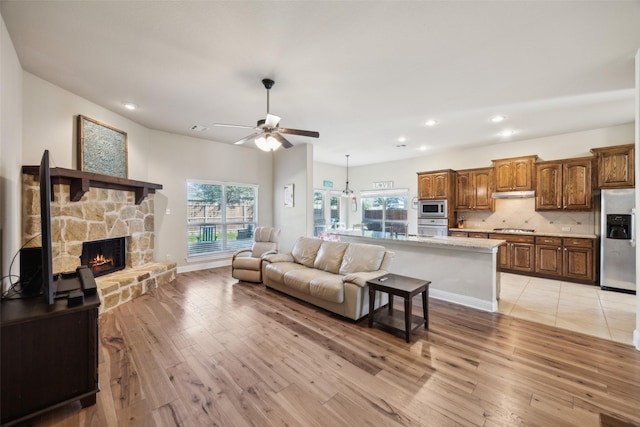 living area with recessed lighting, a fireplace, visible vents, a ceiling fan, and light wood-type flooring