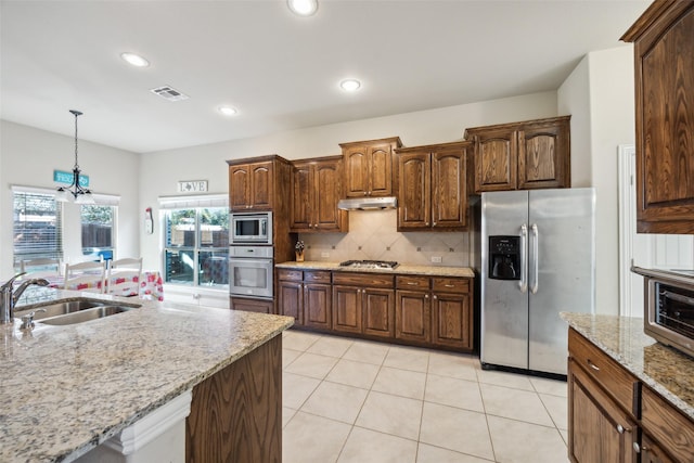 kitchen with stainless steel appliances, visible vents, hanging light fixtures, decorative backsplash, and under cabinet range hood