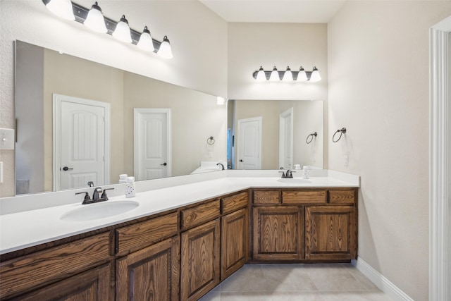 full bath featuring double vanity, tile patterned flooring, and a sink