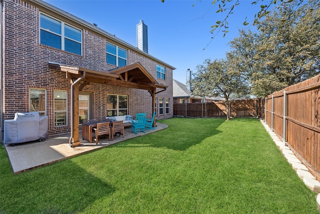 back of property featuring brick siding, a lawn, a patio area, a fenced backyard, and an outdoor living space