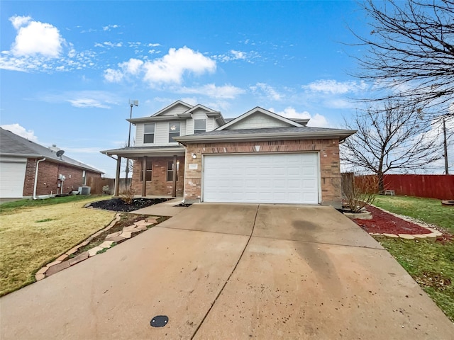 traditional-style home featuring concrete driveway, an attached garage, fence, a front yard, and brick siding