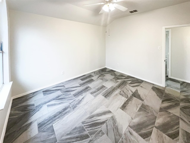 spare room featuring a ceiling fan, visible vents, vaulted ceiling, and baseboards