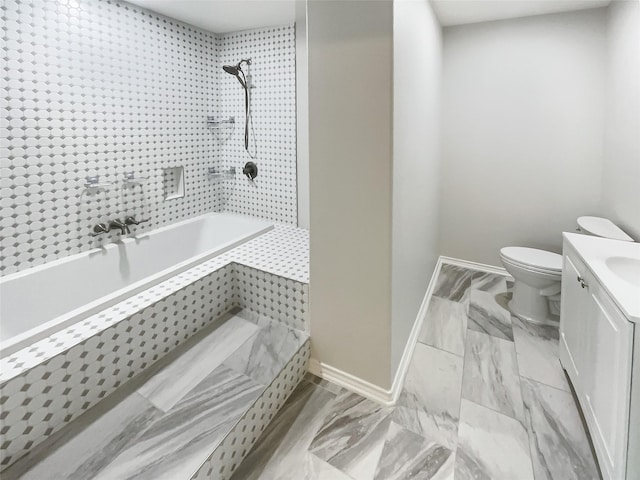 bathroom with tiled tub, vanity, toilet, and baseboards