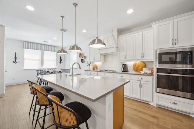 kitchen featuring stainless steel appliances, a sink, and white cabinetry