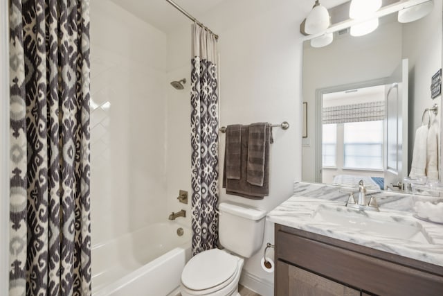 bathroom featuring toilet, shower / bath combo with shower curtain, and vanity