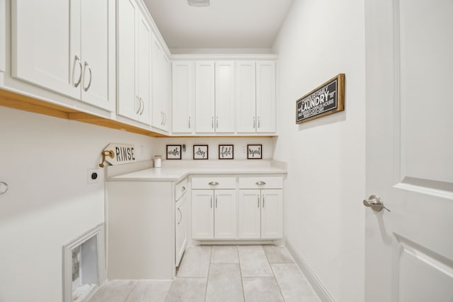 clothes washing area featuring light tile patterned floors, baseboards, cabinet space, and hookup for an electric dryer