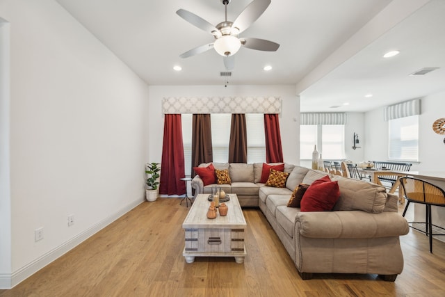 living room with light wood-style floors, baseboards, visible vents, and recessed lighting