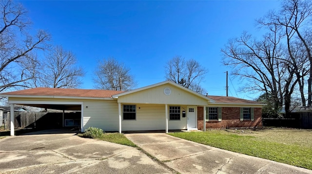 ranch-style house featuring a carport, a front yard, brick siding, and driveway