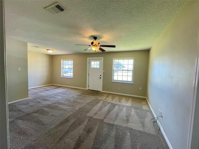 interior space featuring a ceiling fan, baseboards, visible vents, and carpet flooring