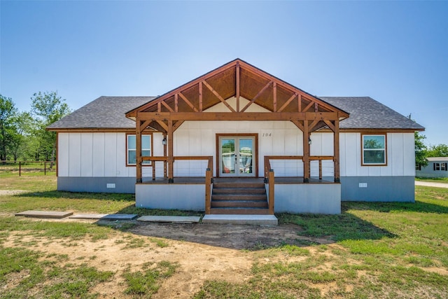 back of property with covered porch, roof with shingles, crawl space, and a lawn