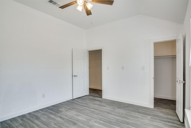 unfurnished bedroom with visible vents, baseboards, vaulted ceiling, a closet, and light wood-type flooring