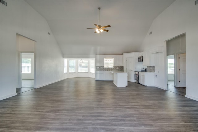 unfurnished living room featuring visible vents, ceiling fan, wood finished floors, high vaulted ceiling, and baseboards