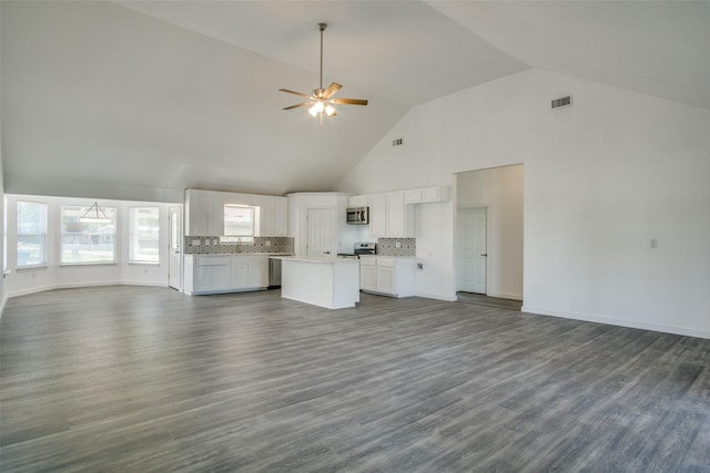 unfurnished living room with baseboards, high vaulted ceiling, dark wood-type flooring, and a ceiling fan