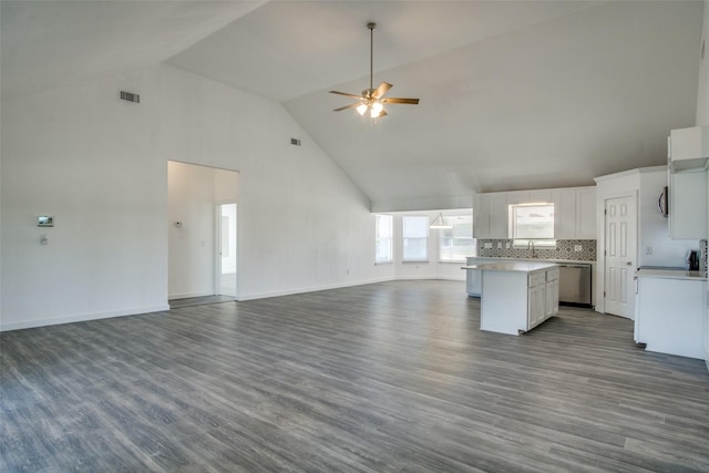 kitchen with light countertops, open floor plan, white cabinetry, and stainless steel dishwasher