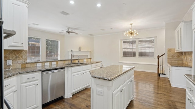 kitchen with stone countertops, a kitchen island, white cabinets, hanging light fixtures, and stainless steel dishwasher