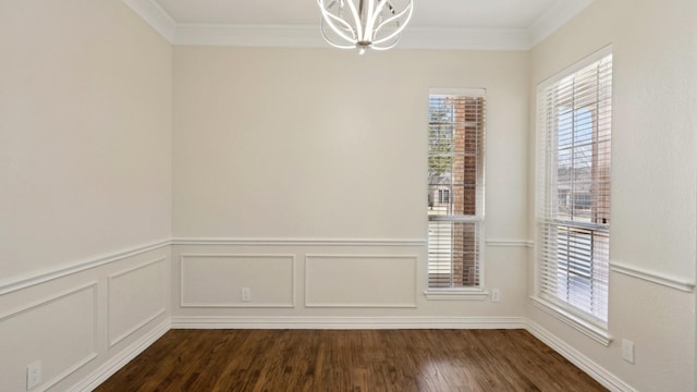 unfurnished dining area featuring dark wood finished floors, a healthy amount of sunlight, crown molding, and an inviting chandelier