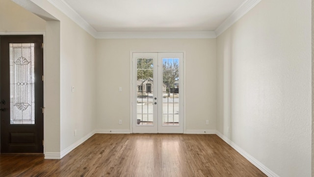 foyer with dark wood-style floors, french doors, crown molding, and baseboards