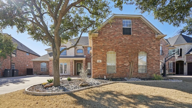 traditional-style home with driveway and brick siding