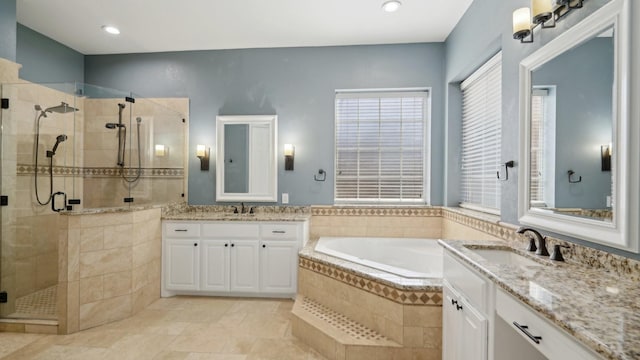 full bath with a stall shower, two vanities, a sink, and a bath