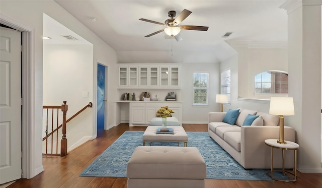 living room with dark wood-style floors, baseboards, visible vents, and a ceiling fan