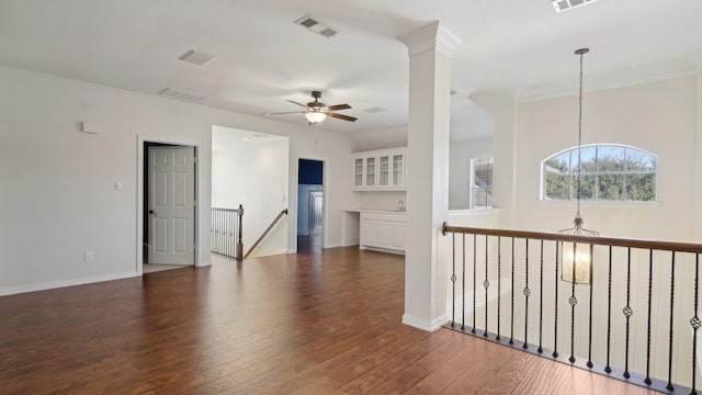 spare room with dark wood-style floors, baseboards, visible vents, and a ceiling fan