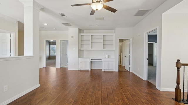 unfurnished living room featuring dark wood-type flooring, visible vents, and built in desk