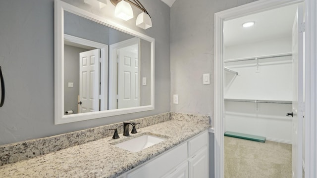 bathroom with a spacious closet and vanity