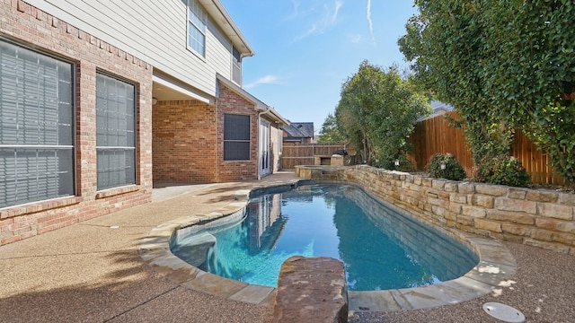 view of pool with a pool with connected hot tub and a fenced backyard